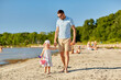 © Syda Productions - family, fatherhood and leisure concept - happy father walking with little daughter on beach