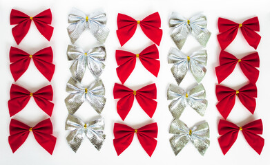 many red and silver festive bows isolated on white background, christmas or birthday or anniversary greeting card, pattern for wrapping paper