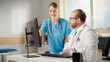 © Gorodenkoff - Doctors Office: Latin Physician Sitting at His Desk Talking With Professional Head Nurse, Using Personal Computer. Medical Health Care Specialists Discussing Test Results, Patient Treatment Plan