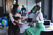 © Wavebreak Media - Asian woman with book and african american woman with digital tablet talking to each other at modern