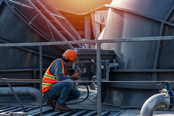 worker open valve of cooling tower on blue sky background. worker opening butterfly valve on top of cooling Tower. engineer check valve on cooling tower.