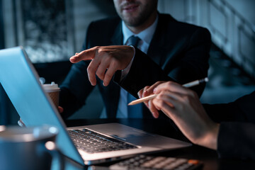 office male manager pointing finger at the laptop screen at night. office business colleagues workin