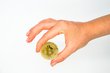 Golden bitcoin between 2 fingers - conceptual image for crypto currency - Future currency - White background