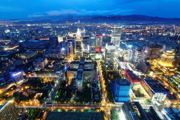 Wall Mural - Aerial skyline of Downtown Taipei at dusk, the capital city of Taiwan, with  Towers standing out among modern skyscrapers in Xinyi Financial District and city lights dazzling under blue twilight sky