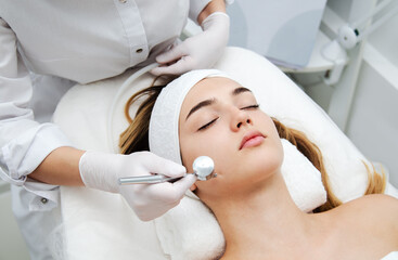 Woman getting face beauty treatment in medical spa center.