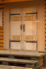 Entrance door with patterns to a wooden house.