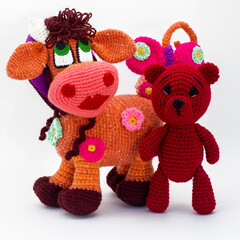 Wall Mural - Amigurumi dolls a cow burgundy teddy bear are walking.