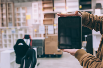 Wall Mural - A man in a furniture store holds a tablet in his hand.