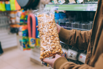 Wall Mural - The guy in the supermarket holds a bag of popcorn.