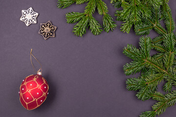 Festive composition with colorful Christmas decoration and fir branches on dark grey background