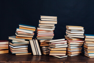 stacks of books for education in the library on a black background place for inscription