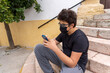 © Manuel - Teenager with Face Mask Using Phone