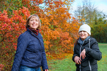 mother and daughter playing and having fun in autumn park, happy people together, parent and children, beautiful nature