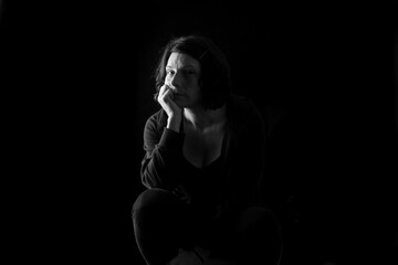 portrait of a woman sitting on black background