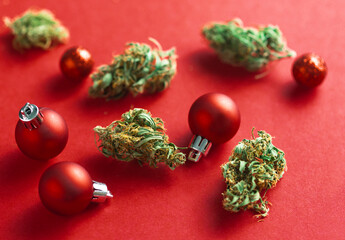 Christmas decorations and Cannabis on red background. 