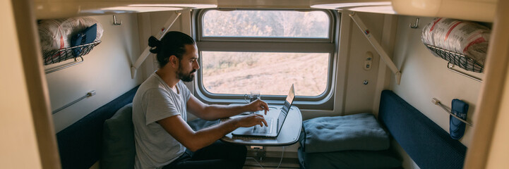 Wall Mural - Man with laptop on the train.