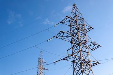 Transmission towers and power lines against blue sky