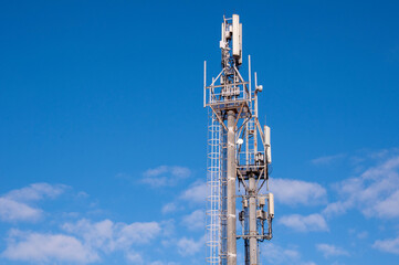 Telecommunication Tower With Blue Sky And White Clouds Background. Antenna On Blue Sky.