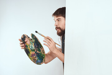 Wall Mural - Male artist hiding behind an easel palette drawing art