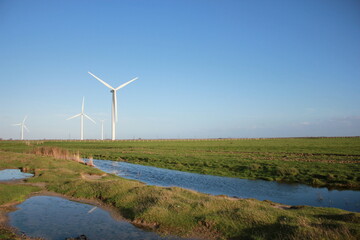 Wind farm turbines that produce electricity energy. Windmill Wind power technology productions Wind turbines standing in green field - stock footage