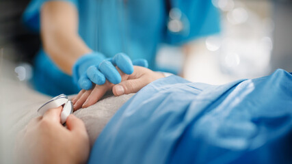 Wall Mural - Hospital Ward: Close-up Shot of a Head Nurse Caring about Patient and Holding His Hand. The Patient is Getting Well after Serious Surgery or Dangerous Disease. Focus on Helping Hand.