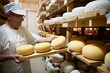 Cheese maker at the storage with shelves full of cow and goat cheese