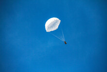 Low Angle View Of People Parasailing In Blue Sky