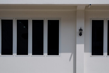 Sunlight and shadow on glass windows surface outside of house building wall