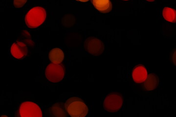 Red bokeh lights on a black background. Christmas lights texture for design