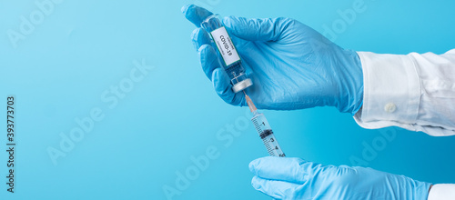Fototapeta na szkło COVID-19 Vaccine vial and injection Needle Syringe against Coronavirus infection in hand of doctor with Nitrile Glove in hospital laboratory. Medical, health, Vaccination and immunization concept