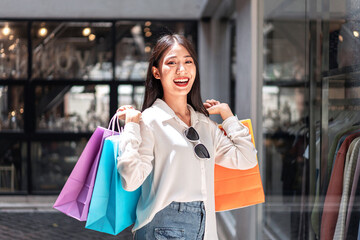 Portrait of Asian girl excited beautiful girl happy smiling with holding shopping bags relaxed expression, Positive emotions shopping, lifestyle concept