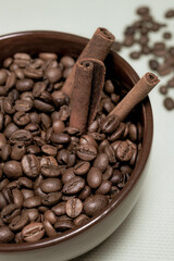 Coffee roasted beans with cinnamon sticks, star anise in brown ceramic mug on blue background half view vertical macro retro style