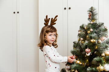 Wall Mural - Funny small girl with decorated Christmas tree.White background.Minimalist style.