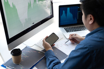 Wall Mural - Stock exchange market concept, stock broker looking at graph working and analyzing with display screen, pointing on the data presented and deal on a exchange, Businessman trading stocks online