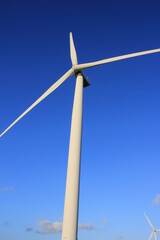 Wind farm turbines that produce electricity energy. Windmill Wind power technology productions Wind turbines standing in green field - stock footage