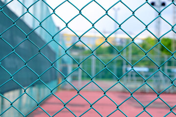 Wall Mural - green wire mesh fence enclosure of tennis court