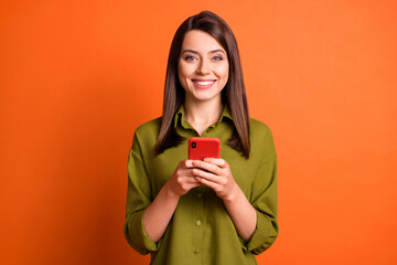 Wall Mural - photo of cheerful positive girl hold cellphone beaming smile look camera wear green shirt isolated o
