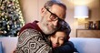 © VAKSMANV - Close up of loving happy Caucasian grey-haired grandpa in glasses spending Christmas together with joyful grandson sitting in decorated room near glowing xmas tree smiling and hugging on New Year Eve