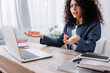 © LIGHTFIELD STUDIOS - laptop and smartphone with blank screen near dissatisfied woman gesturing on blurred background