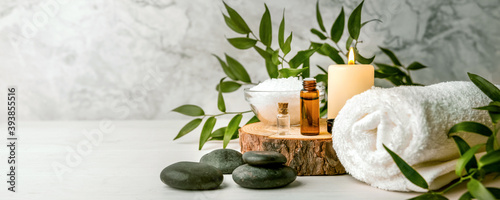 Obraz Dibond beauty treatment items for spa procedures on white wooden table. massage stones, essential oils and sea salt. copy space