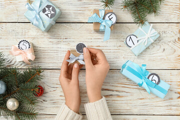 Sticker - Woman making advent calendar at white wooden table, top view