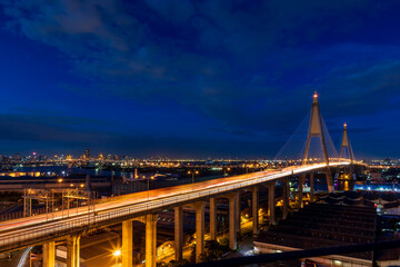 Wall Mural - Large suspension bridge over Chao Phraya river with traffic at twilight
