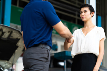 Wall Mural - Expertise mechanic shaking hands with satisfied customer and working in automobile repair maintenance station garage. Satisfaction in service