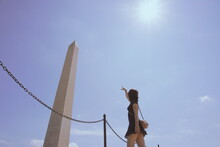 Low Angle View Of Woman Gesturing While Standing Against Sky