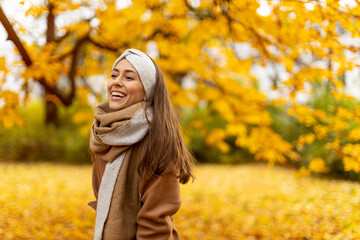 Wall Mural - portrait of smiling young woman in a park in autumn