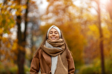 Wall Mural - portrait of smiling young woman in a park in autumn