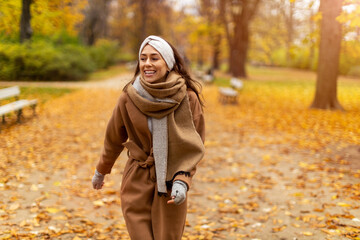 Wall Mural - portrait of smiling young woman in a park in autumn