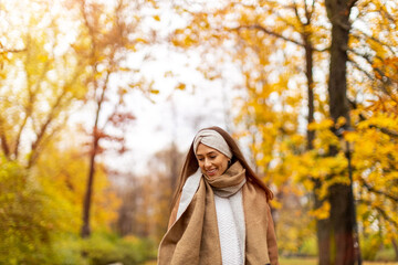 Wall Mural - portrait of smiling young woman in a park in autumn
