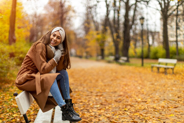 Wall Mural - portrait of smiling young woman in a park in autumn