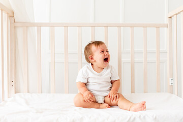 baby boy six months old crying in his crib